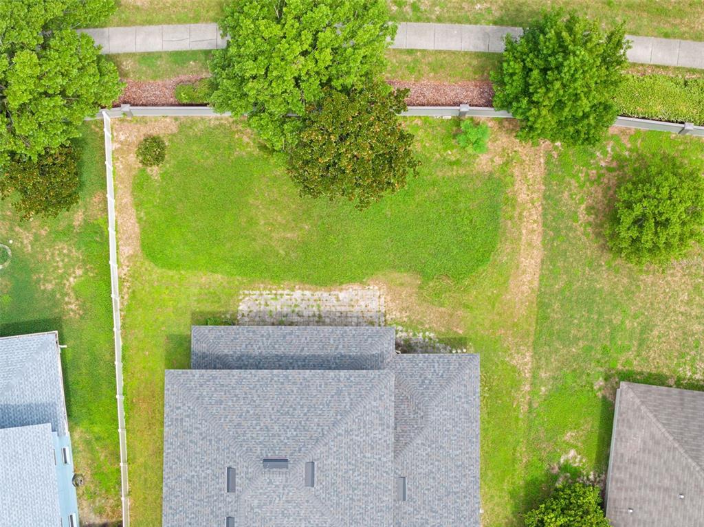 An aerial view shows a house with a shingled roof and a fenced backyard — 4501 BIRCHFIELD LOOP, SPRING HILL, FL