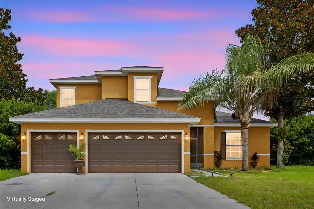 A two-story house with a mustard-yellow exterior, brown garage doors, and a palm tree — 4501 BIRCHFIELD LOOP, SPRING HILL, FL