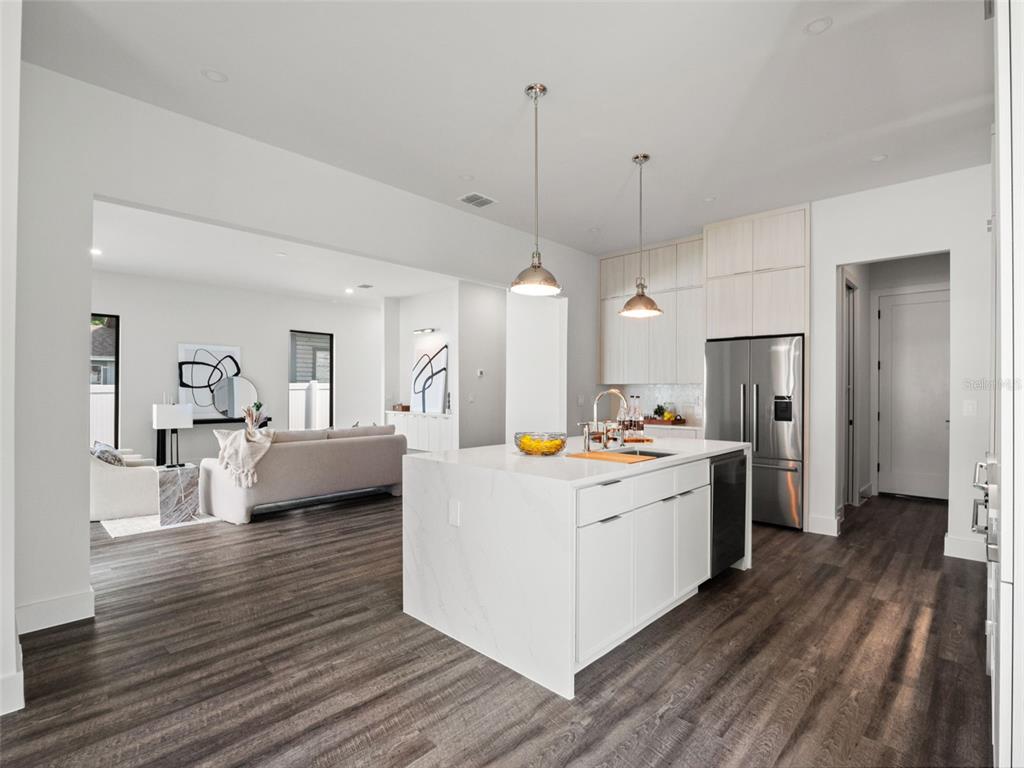 A modern kitchen with a white marble island overlooks an open-concept living area — 1320 CLOVERLAWN AVENUE, ORLANDO, FL