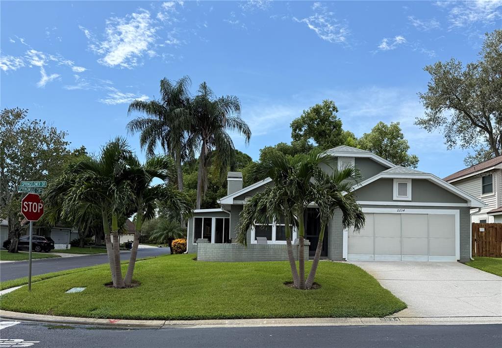 A single-story house with a gray exterior, a two-car garage, and palm trees in front — 2234 SPRINGFLOWER DR., CLEARWATER, FL