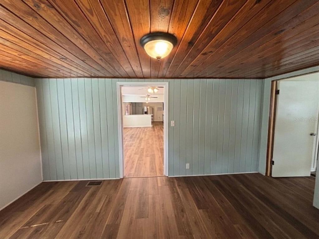 A room with wood-paneled ceilings, light green vertical wall paneling, and wood-look flooring — 320 W BULLARD AVENUE, LAKE WALES, FL