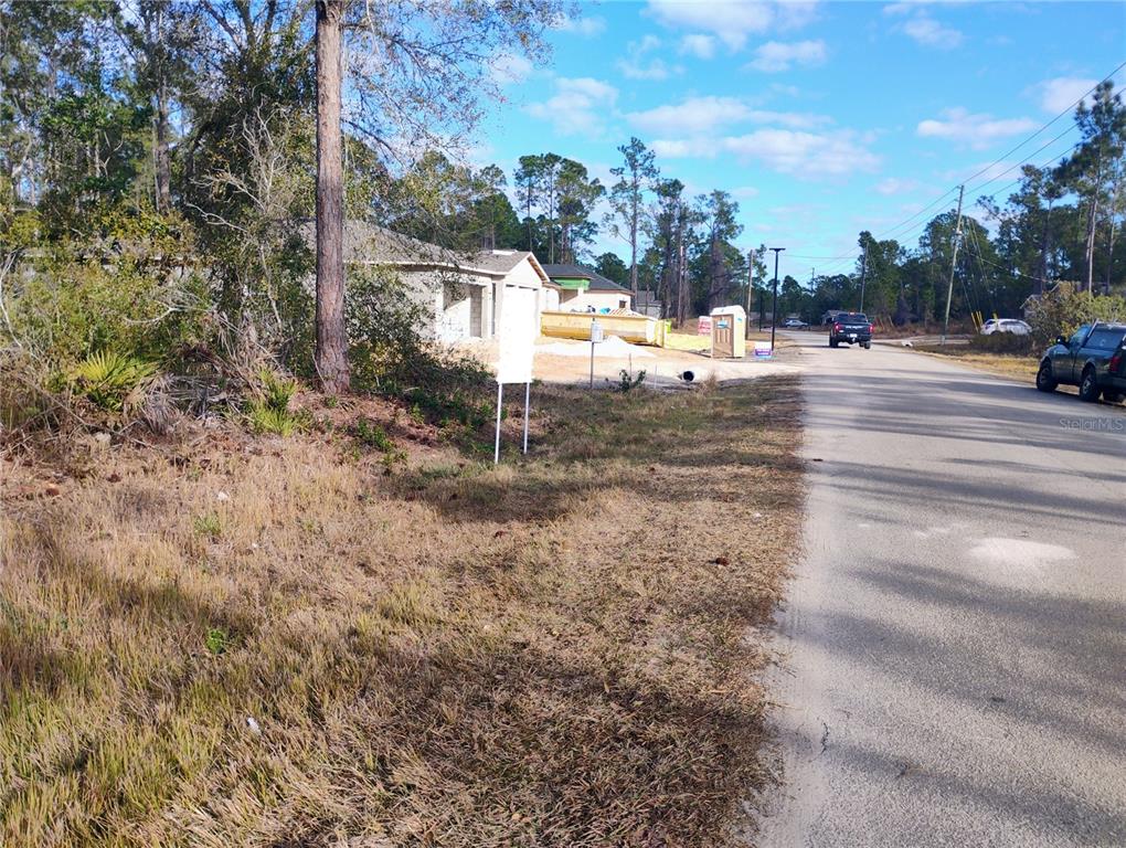A view of a residential street with a house under construction and a portable toilet — 4217 GERONA AVENUE, SEBRING, FL