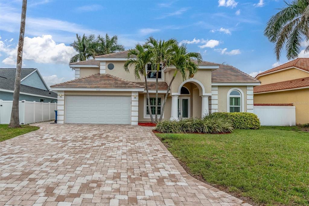 A two-story house with a paved driveway, a two-car garage, and palm trees — 906 LANDMARK CIRCLE S, TIERRA VERDE, FL