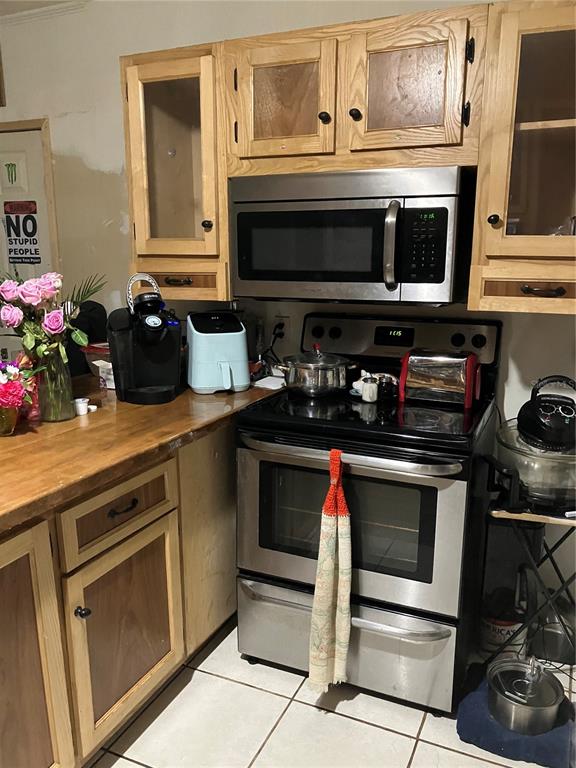 A kitchen features wood cabinets, stainless steel appliances, and a light-colored tile floor — 3012 16TH AVENUE W, BRADENTON, FL