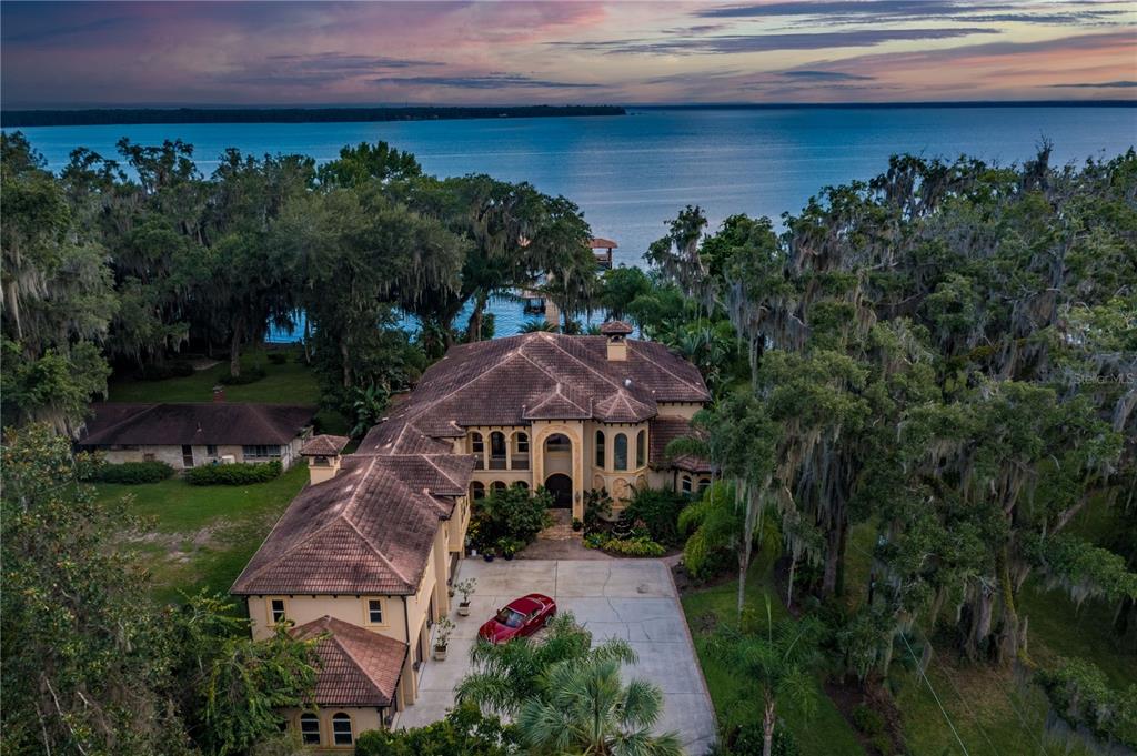 An aerial view of a large Mediterranean-style house with a red car parked outside — 8289 COLEE COVE ROAD, ST AUGUSTINE, FL