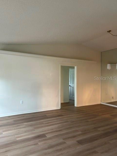 A kitchen features wood cabinets, granite-look countertops, a white microwave, and a tiled floor — 1060 E NORMANDY BOULEVARD, DELTONA, FL