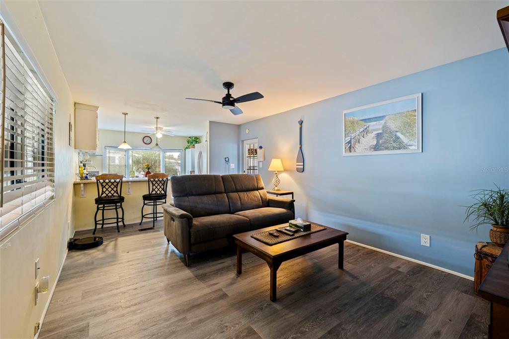A kitchen features white cabinets, a granite breakfast bar, tile flooring, and a dining nook — 6100 62ND AVENUE N UNIT 38, PINELLAS PARK, FL