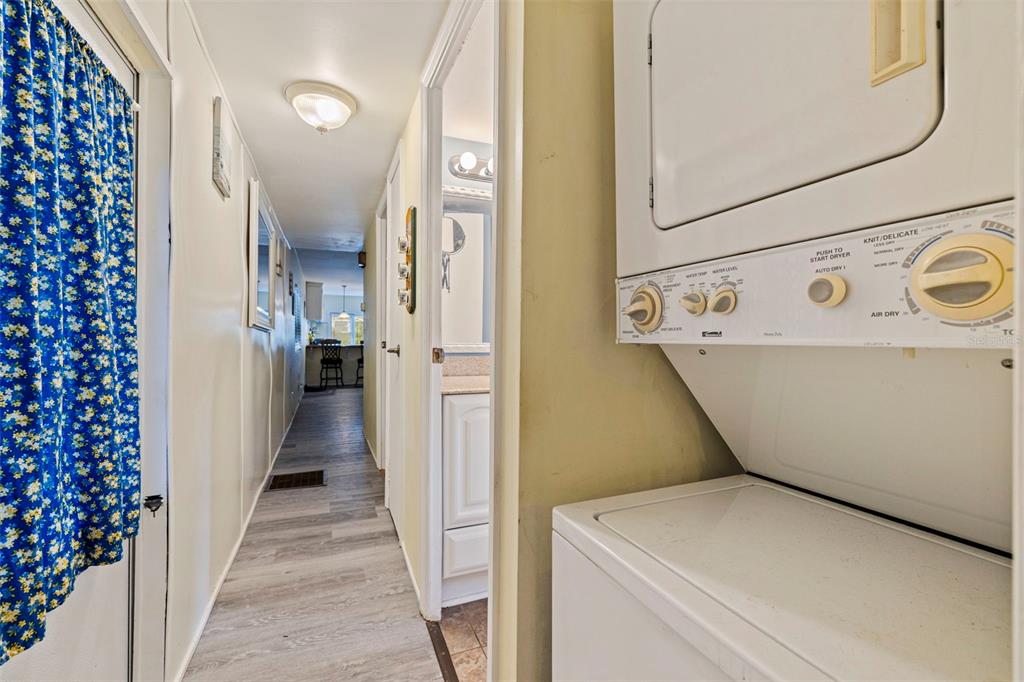 A stacked washer and dryer unit sits next to a bedroom with a blue ceiling — 6100 62ND AVENUE N UNIT 38, PINELLAS PARK, FL