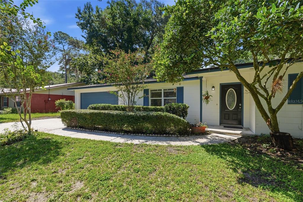 A single-story house with a white exterior, blue shutters, and a curved walkway — 3145 NW 48TH PLACE, GAINESVILLE, FL