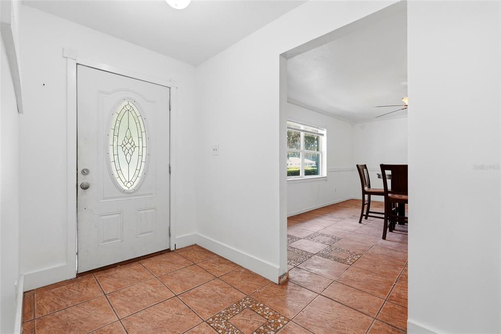A white single-story house features a dark front door, blue shutters, and mature landscaping — 3145 NW 48TH PLACE, GAINESVILLE, FL