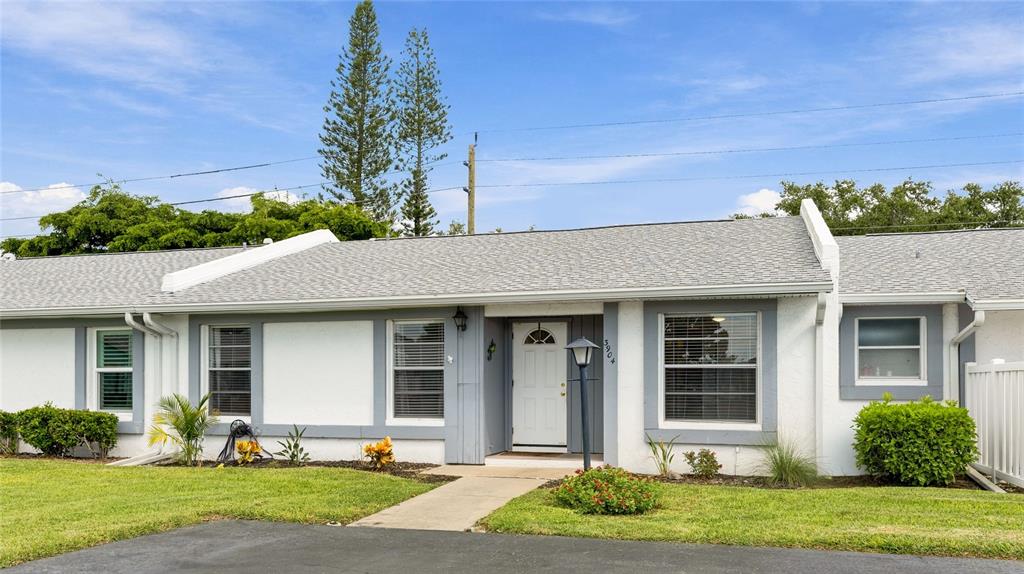 A single-story white house with a gray shingled roof and a front walkway — 3904 36TH AVENUE DRIVE W UNIT 37, BRADENTON, FL