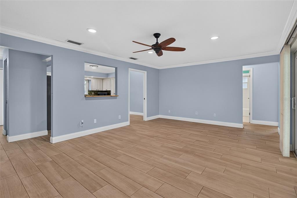 A living room with light blue walls, wood-look tile flooring, and a ceiling fan — 12499 82ND TERRACE, SEMINOLE, FL