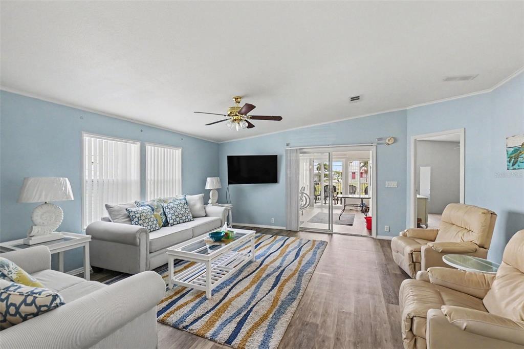 A living room features light blue walls, a striped area rug, and a sliding glass door — 226 BIMINI DRIVE, PALMETTO, FL