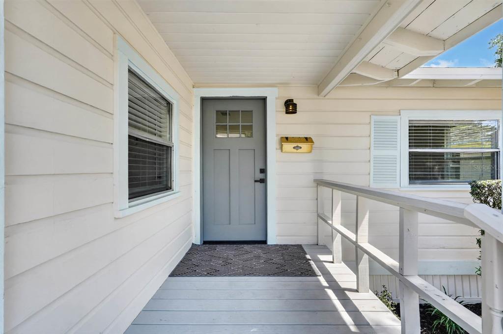 A light-colored house exterior features a gray front door, a porch, and a mailbox — 246 WILLOW PLACE, ORMOND BEACH, FL
