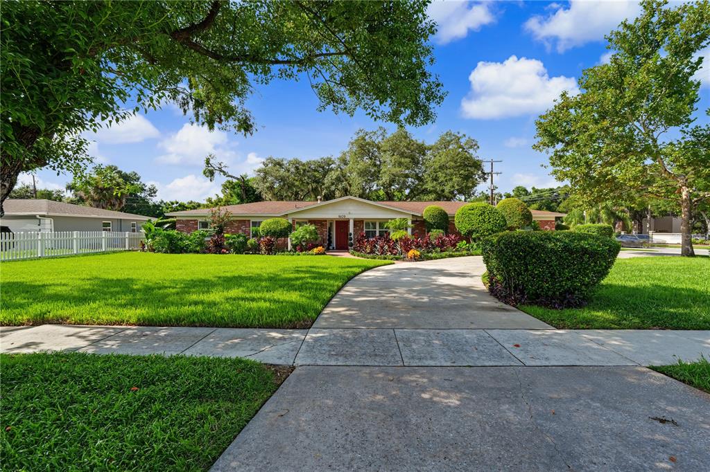 A single-story brick house with a concrete driveway and a large green lawn — 1609 MELODIE DRIVE, BRANDON, FL