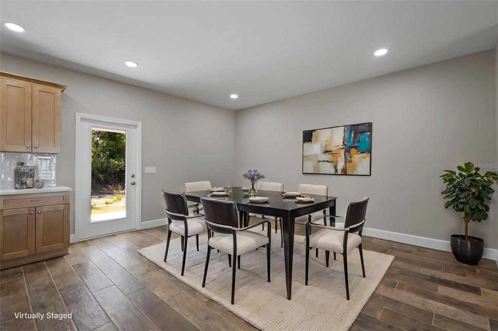 An open-concept living area features a kitchen with wood cabinets and wood-look tile flooring — 9100 DORIE DRIVE, TRENTON, FL