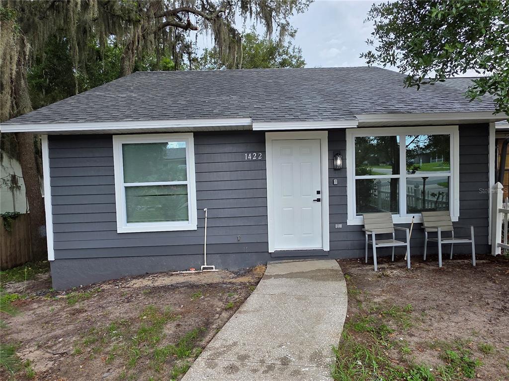 A gray-sided house with a white door, two windows, and a concrete walkway — 1422 PLYMOUTH AVENUE, MOUNT DORA, FL