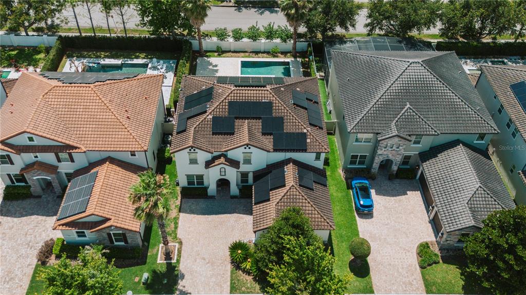 An aerial view shows three suburban houses with tiled roofs, solar panels, and backyard pools — 11768 HAMPSTEAD STREET, WINDERMERE, FL