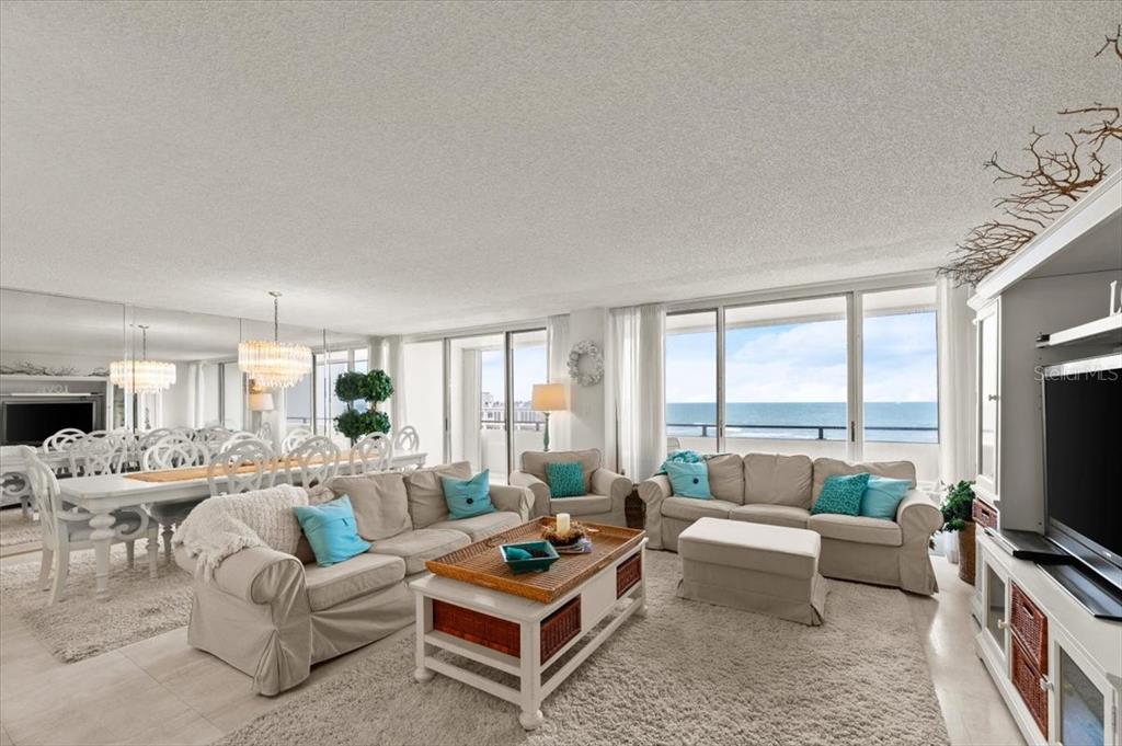A living and dining room with beige furniture, a coffee table, and ocean views — 901 S ATLANTIC AVENUE UNIT PH3, ORMOND BEACH, FL