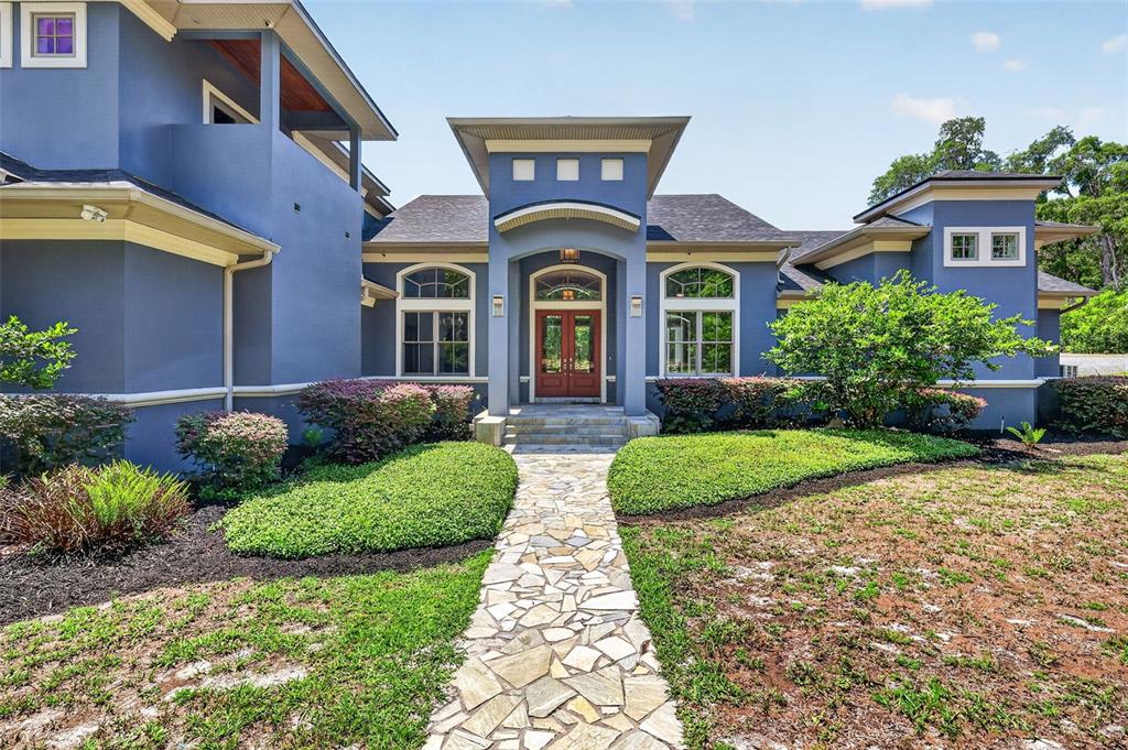 A blue house with a stone walkway leading to a double front door entrance — 2110 HIGHLAND PARK ROAD, DELAND, FL