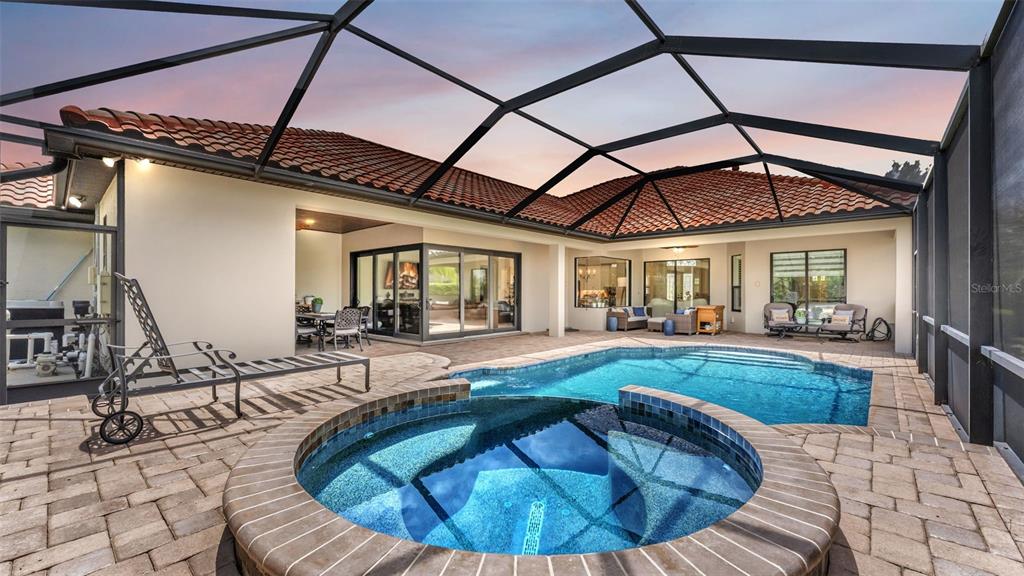 A screened-in patio features a swimming pool, a circular hot tub, and paver flooring — 6538 EAGLE VIEW LOOP, LAKELAND, FL