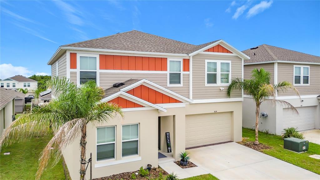 An aerial view shows a suburban neighborhood with rows of houses and a large field — 1414 SEA GLASS ROAD, HAINES CITY, FL