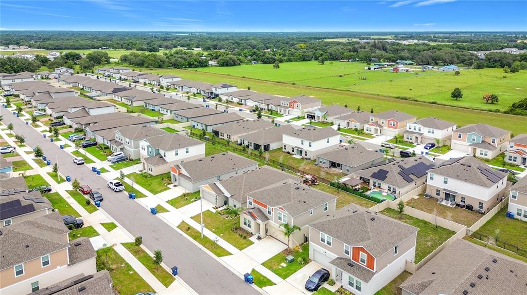 A two-story suburban house with tan siding, orange accents, and a two-car garage — 1414 SEA GLASS ROAD, HAINES CITY, FL