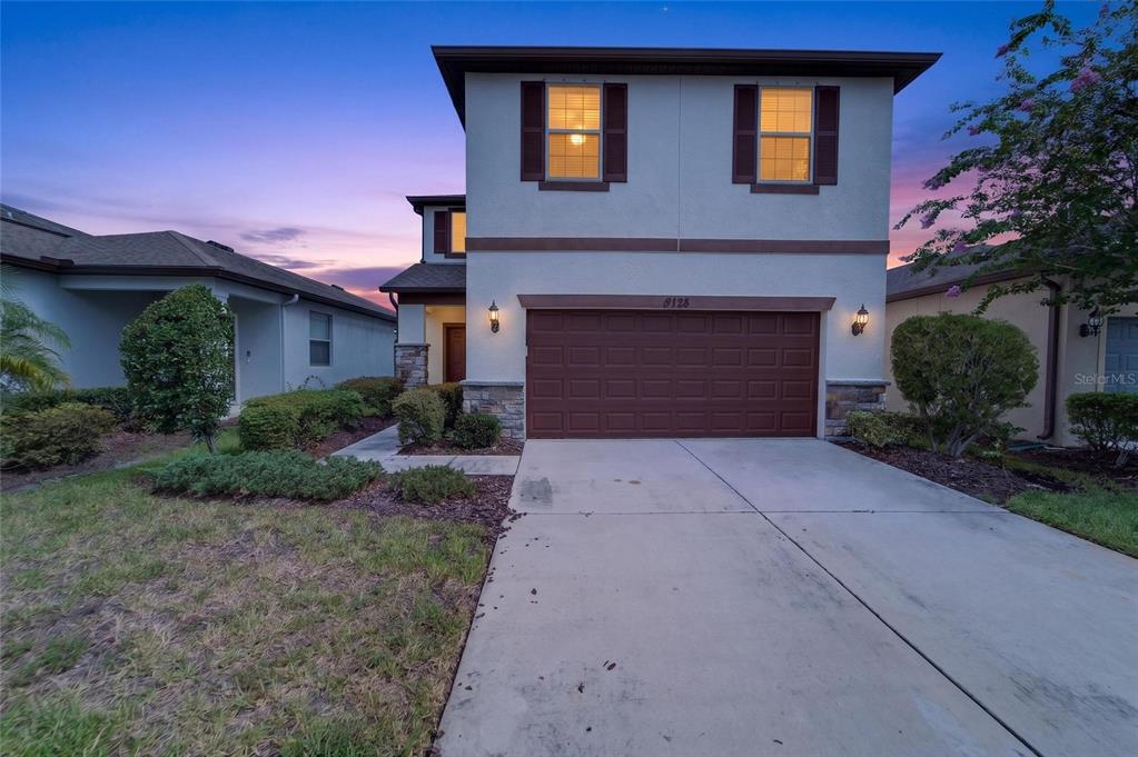 A two-story house with a brown garage door, stucco exterior, and a concrete driveway — 9128 GRANT LINE LANE, RIVERVIEW, FL