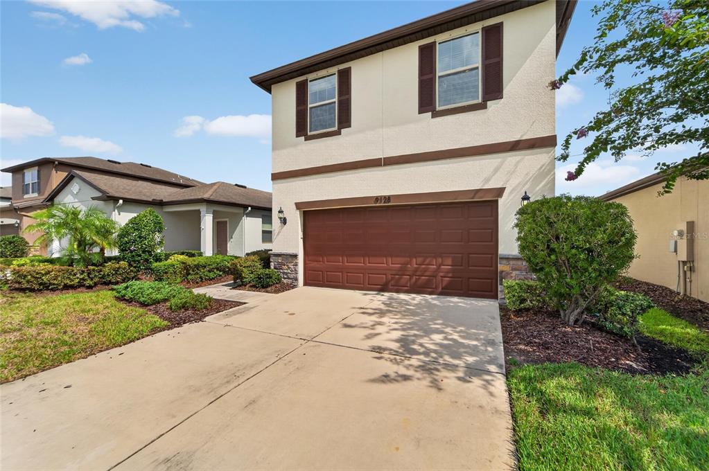 A two-story house with a brown garage door and a concrete driveway — 9128 GRANT LINE LANE, RIVERVIEW, FL