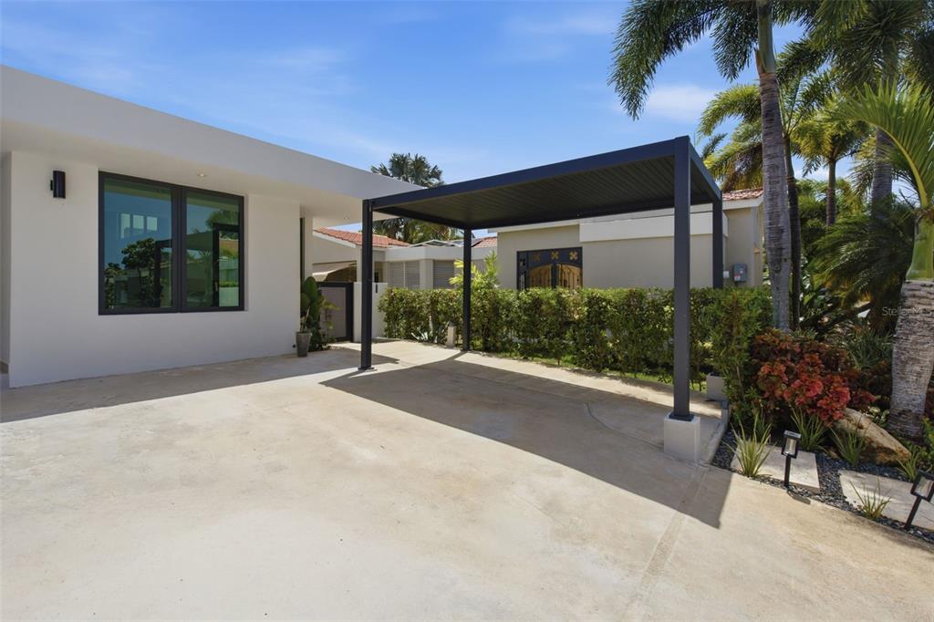 A modern kitchen features a large marble-topped island, dark wood cabinetry, and two wall-mounted air conditioners — 241 CAMINO DEL JAGUEY, DORADO, PR