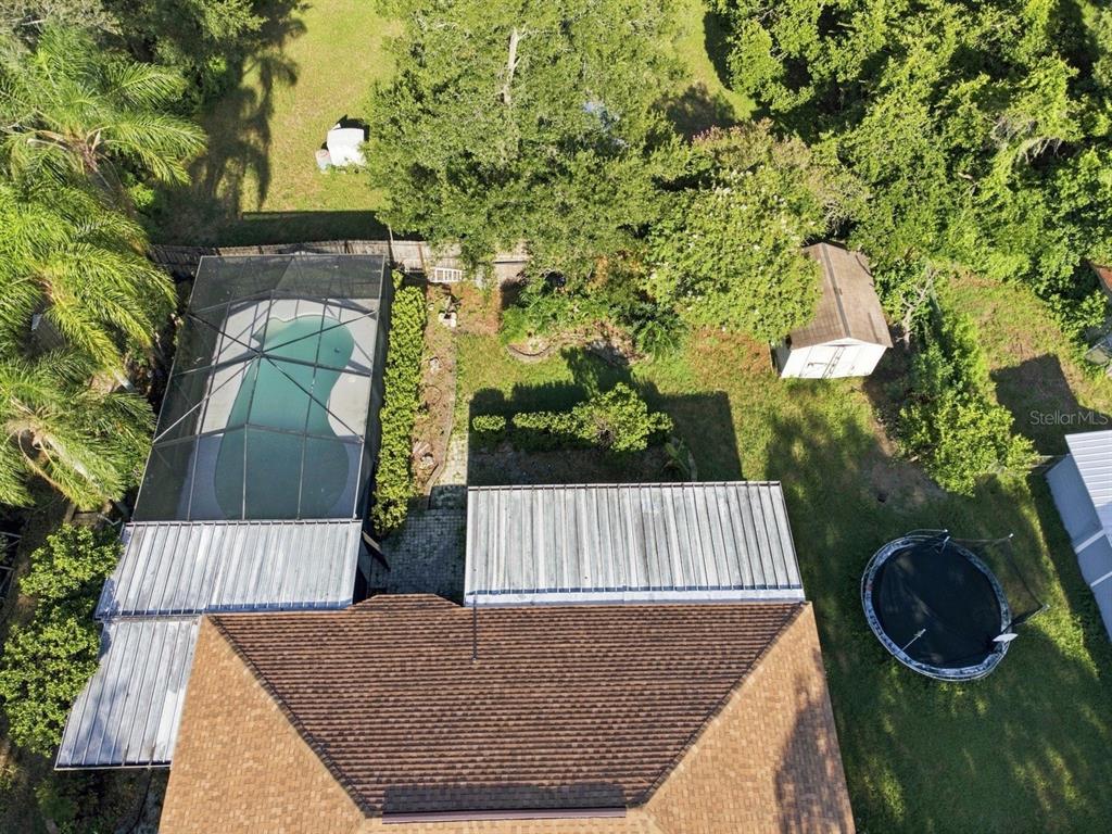 An aerial view shows a house with a screened-in pool, a shed, and a trampoline — 207 LIMONA ROAD, BRANDON, FL