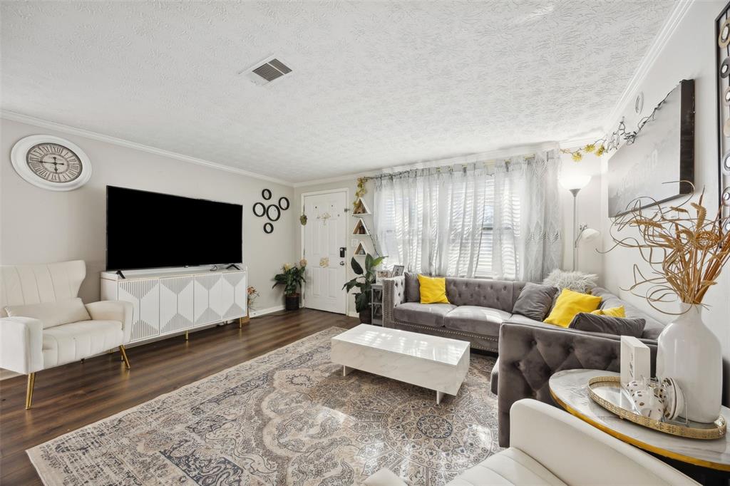 A living room features a grey tufted sectional, white accent chair, and a patterned area rug — 321 ARIES DRIVE, ORANGE PARK, FL