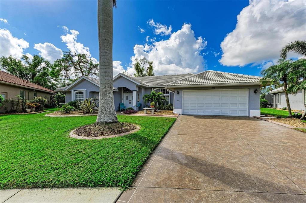 A single-story house with a gray exterior, a two-car garage, and a large palm tree — 316 ROSELING CIRCLE, VENICE, FL