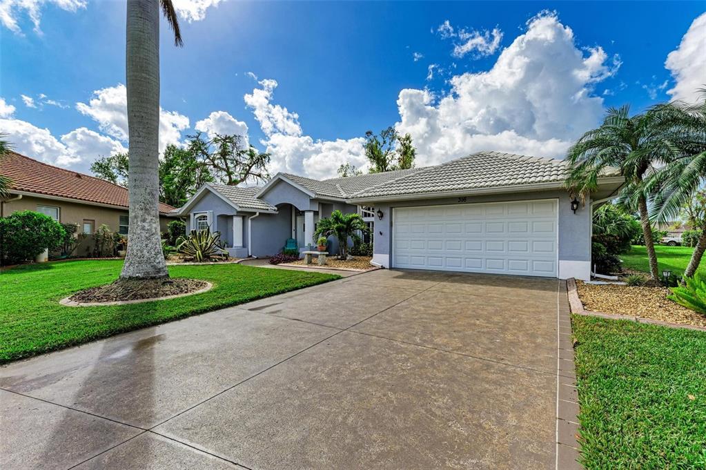 A single-story house with a white garage door, gray exterior, and a paved driveway — 316 ROSELING CIRCLE, VENICE, FL
