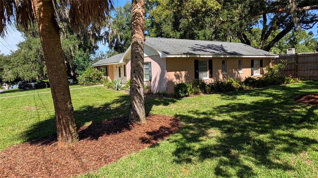 A single-story house with a light pink exterior, a gray roof, and a front lawn — 2469 BROADVUE AVENUE, EUSTIS, FL