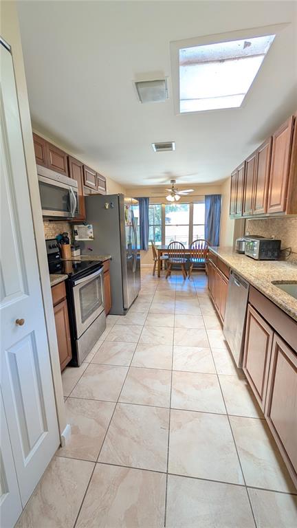 A living room features hardwood floors, a large window, and several pieces of wooden furniture — 2469 BROADVUE AVENUE, EUSTIS, FL