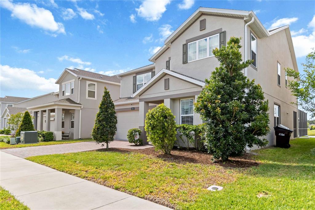A two-story suburban house with a paved driveway, a small front lawn, and landscaping — 5022 DOWN COURT, ST CLOUD, FL