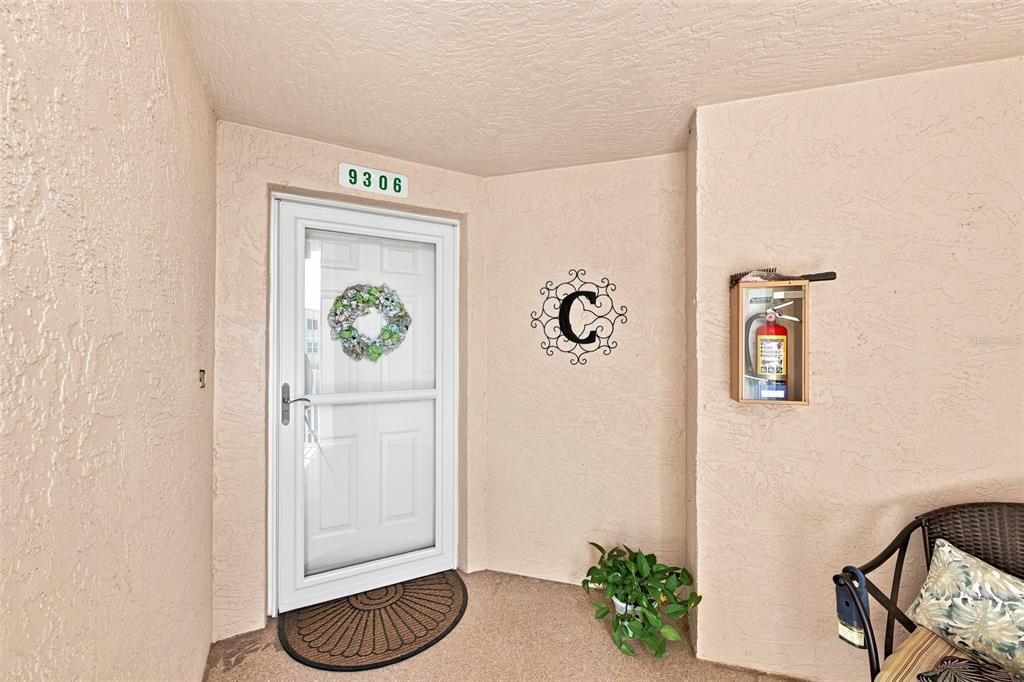 A front entryway features a white storm door, a house number, and a wall-mounted fire extinguisher — 6450 SHORELINE DRIVE UNIT 9306, SEMINOLE, FL