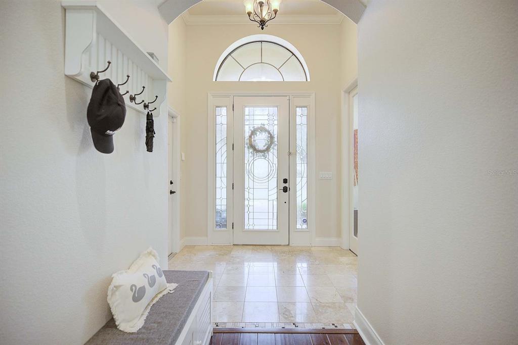 An entryway features a white front door with glass panels, a bench, and tile flooring — 904 CHRISTINA CHASE LANE, LAKELAND, FL