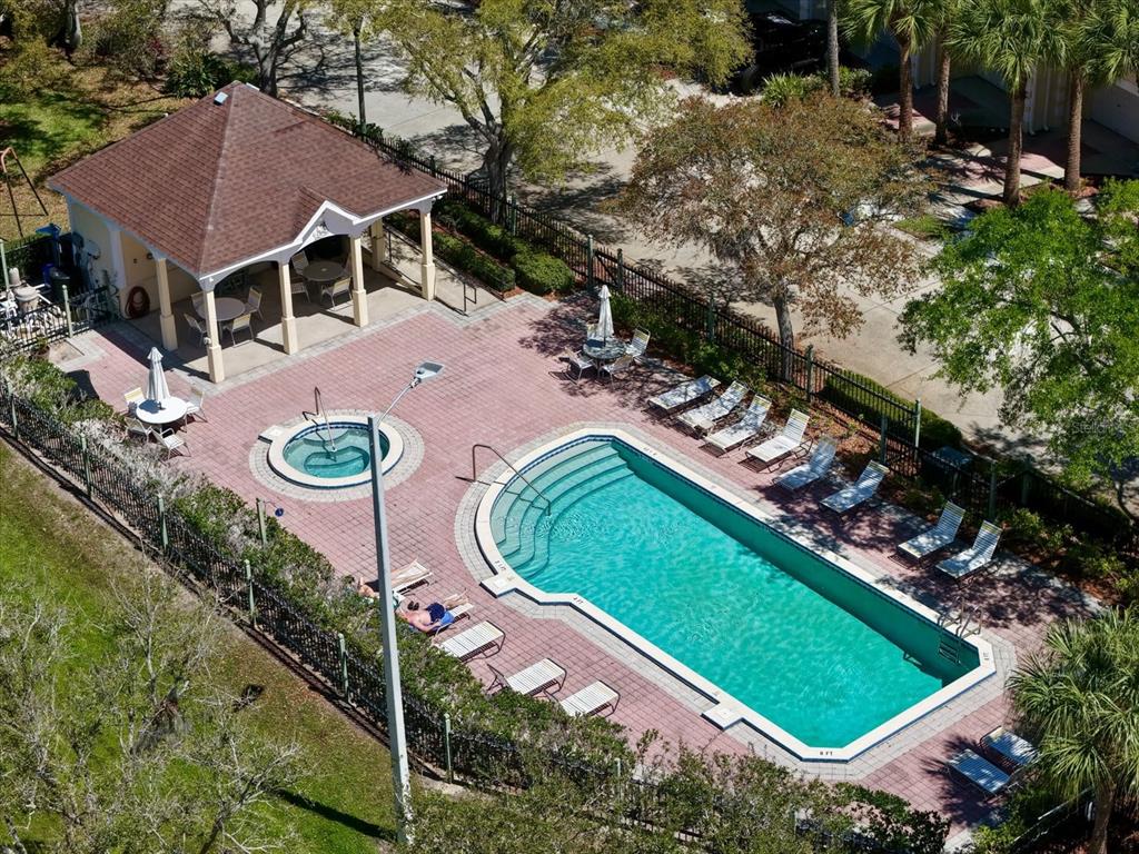 An aerial view of a community swimming pool, hot tub, and covered patio area — 108 BRENT CIRCLE, OLDSMAR, FL