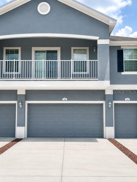 A two-story building with a stone-accented gated entrance and a speed limit sign — 8427 BLUE ROCK DRIVE, NEW PORT RICHEY, FL