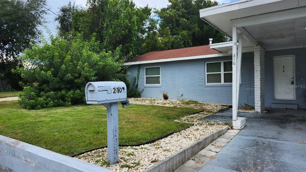 A light blue, single-story house with a white mailbox and a covered front entryway — 210 FRANCIS PARKMAN PLACE, DAYTONA BEACH, FL