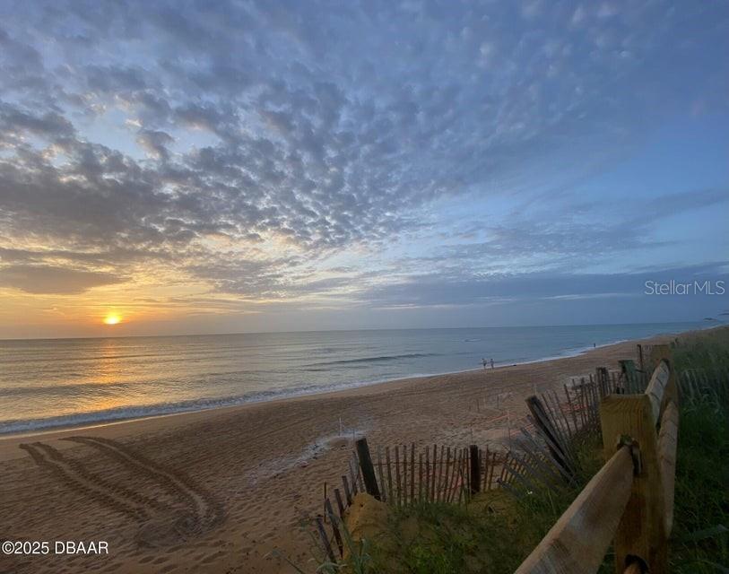 A sandy beach at sunrise with a wooden fence in the foreground — 3780 JOHN ANDERSON DRIVE, ORMOND BEACH, FL