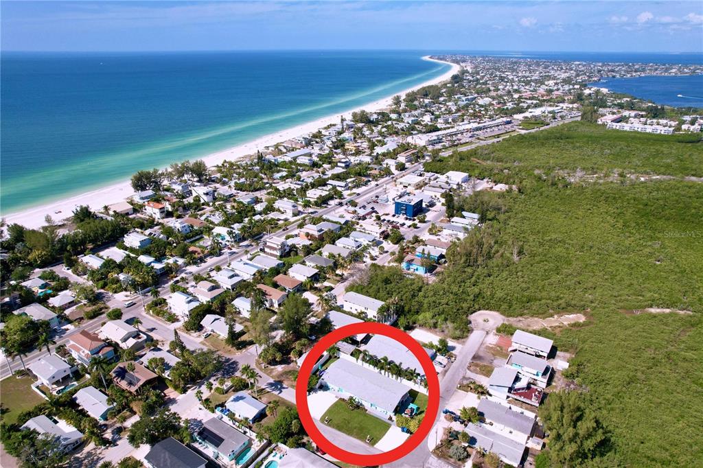 An aerial view shows a single-story house with a yard circled in red — 304 29TH STREET UNIT A, HOLMES BEACH, FL