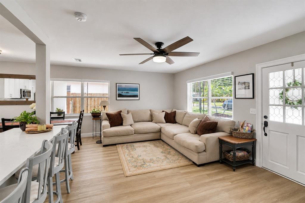 A living room features a beige sectional sofa, a ceiling fan, and light wood flooring — 1623 SAN MATEO DRIVE, DUNEDIN, FL