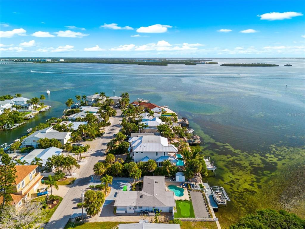 An aerial view shows waterfront houses with pools and docks along a coastal inlet — 511 BAYVIEW DRIVE, HOLMES BEACH, FL