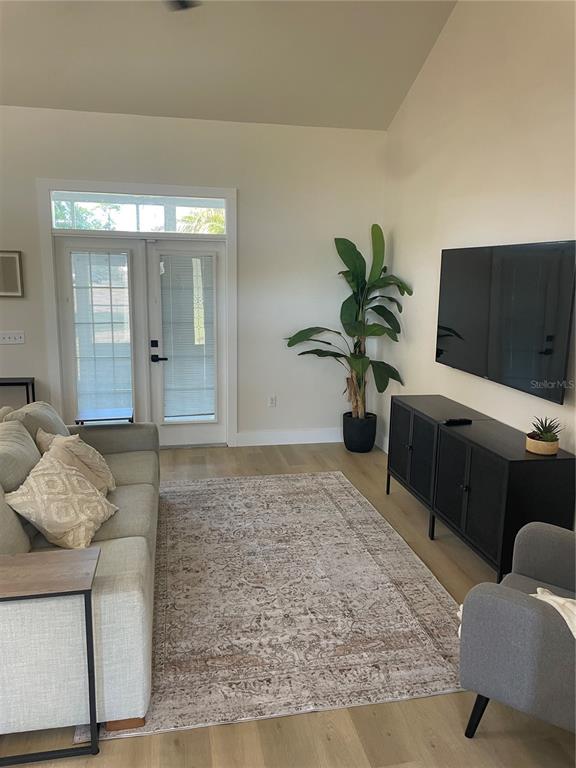 A living room features a light-colored sofa, a black media console, and a potted plant — 37015 WALDO DRIVE, DADE CITY, FL