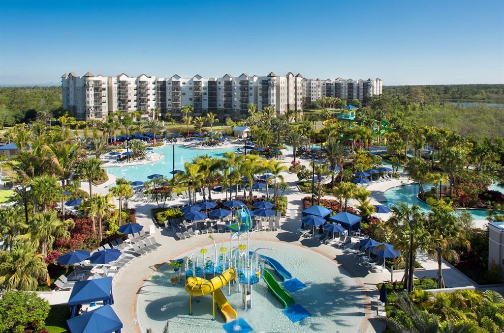 An aerial view of a resort pool complex with water slides and multi-story apartment buildings — 14501 GROVE RESORT AVENUE UNIT 1318, WINTER GARDEN, FL