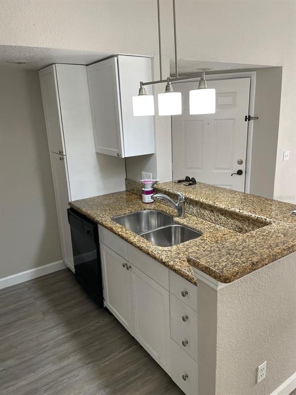 A kitchen features white cabinets, granite countertops, a double-basin sink, and a black dishwasher — 5140 CONROY ROAD UNIT 35, ORLANDO, FL