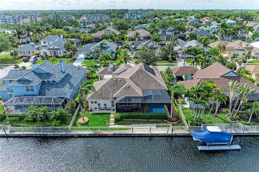 An aerial view of a waterfront house with a pool, screened lanai, and boat dock — 4735 SPINNAKER DRIVE, BRADENTON, FL